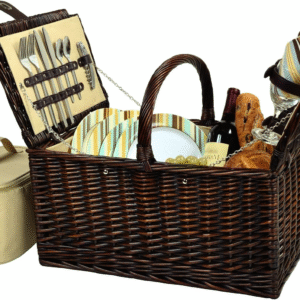 Wicker picnic basket filled with plates, utensils, and a teddy bear.